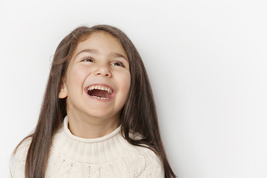 Por Tetyana Kaganska ID de foto en stock libre de regalías: 1274111734 Portrait of a happy smiling child girl with long dark hear. Posivite laughing face.
