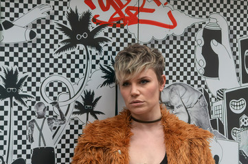 Close up portrait of a young woman next to a wall.