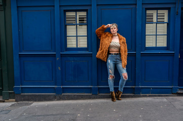 Young woman standing in front of a blue street