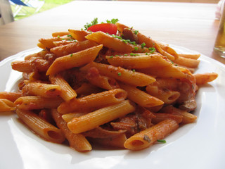 Italian penne pasta with tomato sauce, cream, mushrooms, bacon and chives