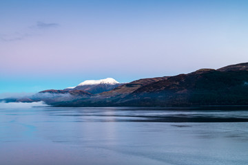 Fototapeta na wymiar Mist on Loch Linnhe with a snowcapped Ben Nevis in the background.