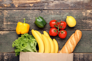 Grocery shopping bag with food on grey wooden table