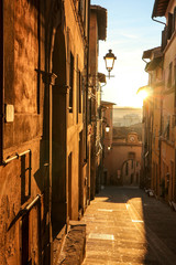 Obraz premium Narrow street in medieval tuscany town Castelfiorentino at the sunset, Italy