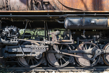 Old rusty wheels of the steam locomotive  and the elements of the drive