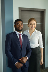 stylish man in a suit next to a woman at work in the office