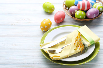 Kitchen cutlery with easter eggs and mimosa flower on wooden table
