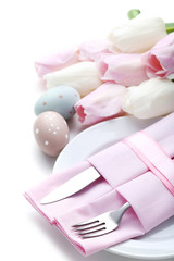 Kitchen cutlery with easter eggs and tulip flowers on white background