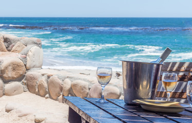 Fototapeta na wymiar Wine glasses at a rustic beach restaurant table facing the Atlantic Ocean - Image