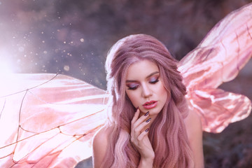 cute faun girl with rose hair with glowing bright pink butterfly wings sit alone in the forest in...