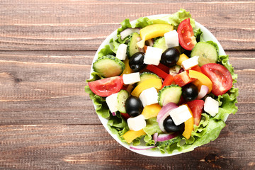 Vegetable salad in bowl on brown wooden table