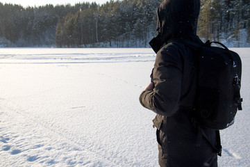 Fototapeta na wymiar A man walking in the snow. Silhouette of a man walking on a snowy plain. Snowflakes falling