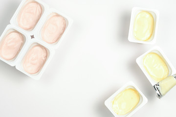 Plastic cup with tasty yogurt isolated on white. Top view. Space for text or design.