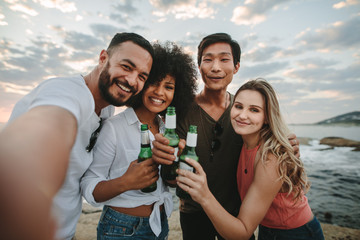 Friends taking a selfie standing at the beach