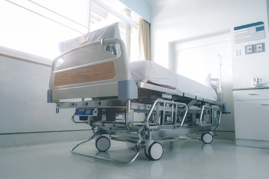 Empty hospital bed in hospital ward