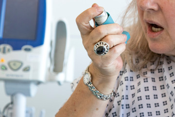 Woman using a blue asthma inhaler