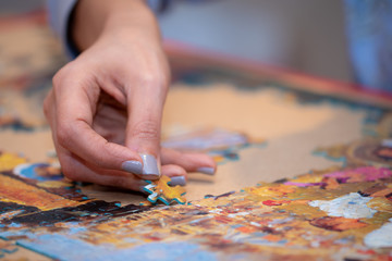 Obraz premium Adult and child solving a jigsaw puzzle on a table. 