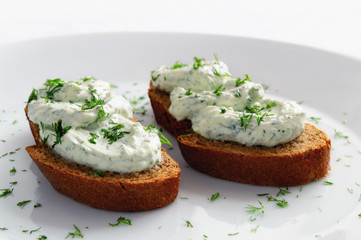 cottage cheese, feta, and dill paste on black bread decorated with dill