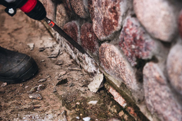 Worker use concrete electric drill (breaker). Crushing of concrete or stone.