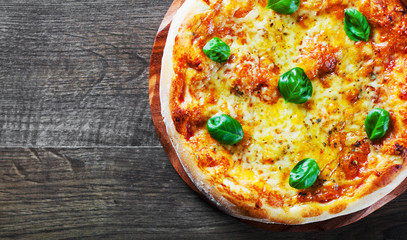 Pizza with Mozzarella cheese, Tomatoes, pepper, Spices and Fresh Basil. Italian pizza. Pizza Margherita or Margarita on wooden table background