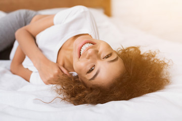 African-american girl lying on bed in the morning