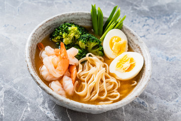 Asian soup with udon with shrimps, egg and broccoli
