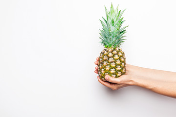 Ripe pineapple woman's in hand isolated on white background.