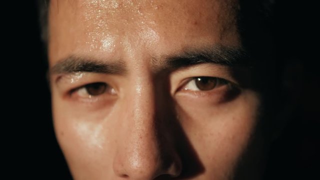 Portrait of asian handsome man standing at the sun light wear boxing glove in the gym. Tired chinesse korean man close up