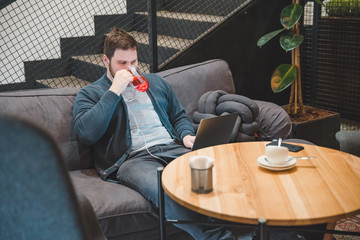 man sitting in cafe with headset and laptop. working in cafe. freelance concept