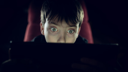 Kind blickt auf Bildschirm