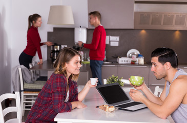 Female helping guy to plan tourist itinerary at hostel kitchen