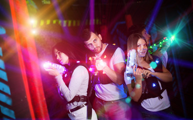 Fototapeta na wymiar Young people on lasertag in colorful beams