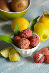 lychees fruits in the white bowl with citrus fruit around
