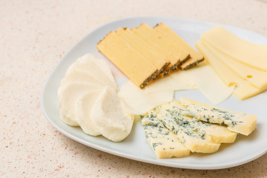 Assorted cheese sliced cheese on white plate