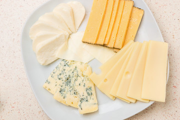 Assorted cheese sliced cheese on white plate