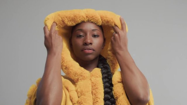 black mixed race model put on a hood with fzux fur. studio beauty shoot