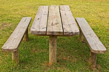 Fototapeta premium A wooden park bench. Outdoor eating or picnic concept image. 