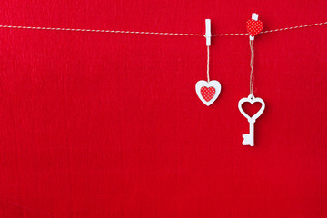 Fototapeta na wymiar Close up of White wooden heart simbol and key on red paper background.