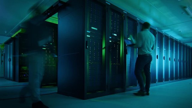 Time Lapse Footage of IT Employees Working in a Data Center Server Room. Technicians and Engineers Running Diagnostics and Maintenance, Inspecting Server Racks.