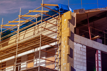 Small building under construction with scaffolding at sunset