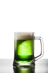 Glass of fresh cold green beer on a wooden table. Isolated