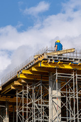 Fototapeta premium Man in protect wear looking through surveyor on building element