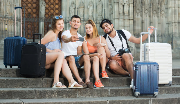 Four Travellers Smiling And Making Selfie