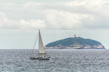 Fototapeta premium Sailing boat near an island, in Copacabana, Rio de Janeiro, Brazil.
