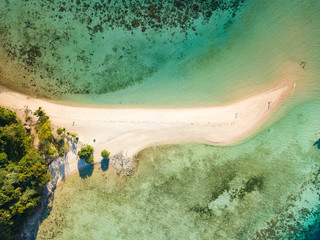 Aerial top view of tropical  beach on island Ditaytayan. Beautiful tropical island with white sandy beach, palm trees and green hills. Travel tropical concept. Palawan, Philippines