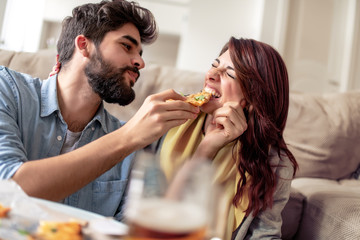 Couple eating pizza at home,enjoying together