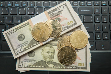 Golden bitcoin coin on us dollars close up. Symbolic image of virtual currency.