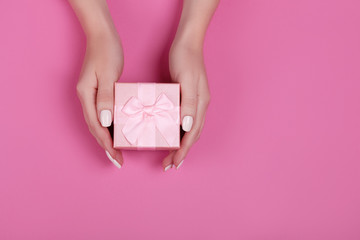 top view hand woman holding pink gift box for valentines day on pink pastel color background