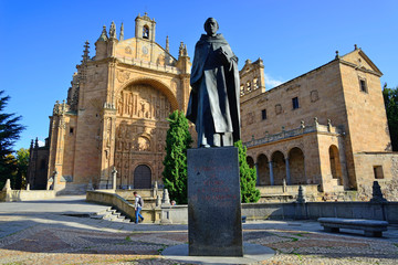 Salamanca, Spain - November 15, 2018: Sculpture of Father Francisco de Vitoria and the Convent of San Esteban in the background.