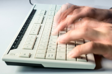 Mann tippt schnell auf eine Computertastatur