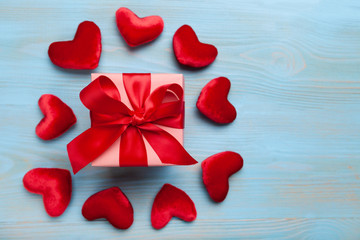 Gift or present box with red bow ribbon and glitter heart on blue background for Valentines day